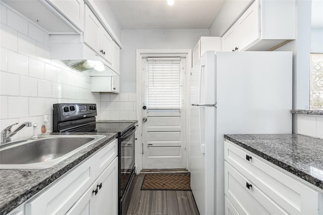 4507 9th St W Unit A2, Bradenton, FL 34207 - kitchen featuring black range with electric cooktop, freestanding refrigerator, white cabinets, dark wood finished floors, and tasteful backsplash