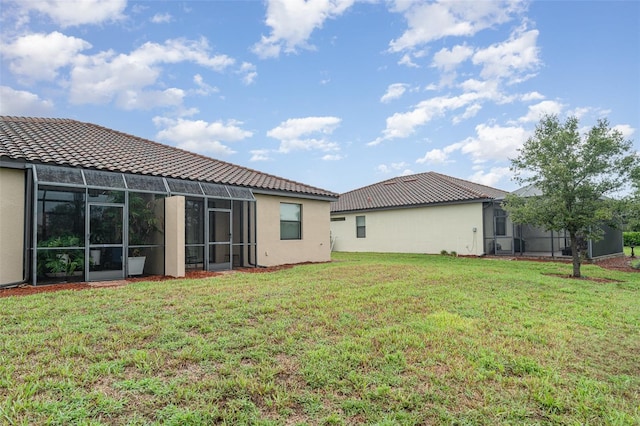12515 Garibaldi Ln, Venice, FL 34293 - rear view of property featuring a lawn, stucco siding, and a tile roof
