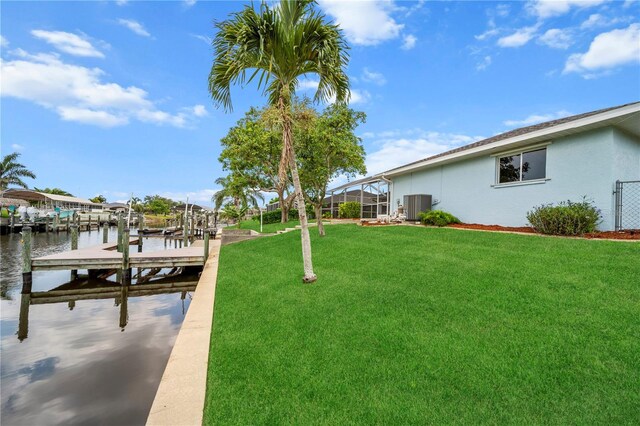1314 SE 15th Ter, Cape Coral, FL 33990 - view of green lawn featuring central AC, a boat dock, boat lift, a water view, and glass enclosure