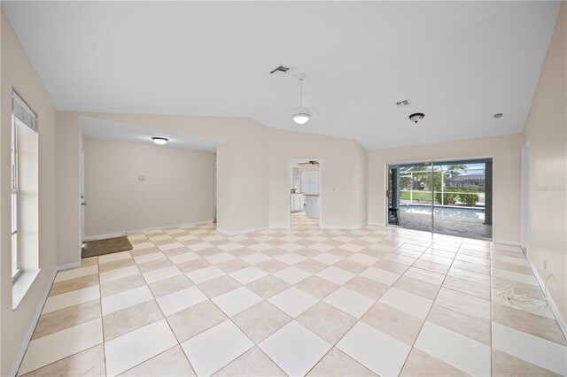 1314 SE 15th Ter, Cape Coral, FL 33990 - empty room with vaulted ceiling, baseboards, and light tile patterned floors