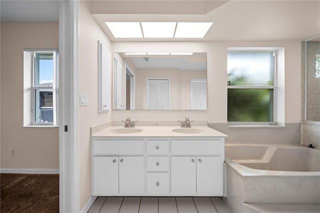 1314 SE 15th Ter, Cape Coral, FL 33990 - bathroom featuring double vanity, a garden tub, and a skylight