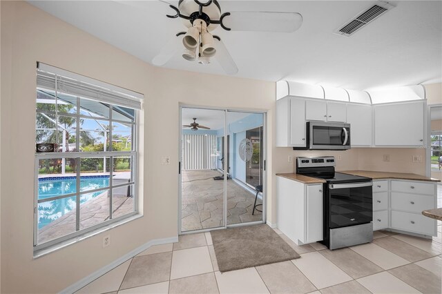 1314 SE 15th Ter, Cape Coral, FL 33990 - kitchen featuring stainless steel appliances, ceiling fan, white cabinetry, baseboards, and light tile patterned flooring