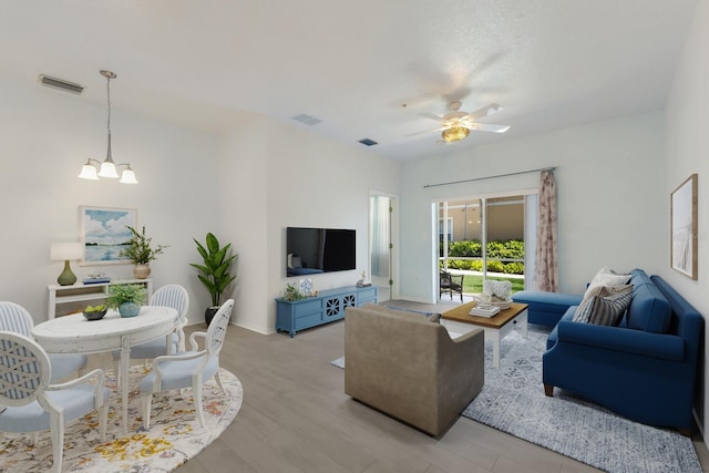 3402 Parkridge Cir, Sarasota, FL 34243 - living area featuring a chandelier, ceiling fan, wood finished floors, and baseboards