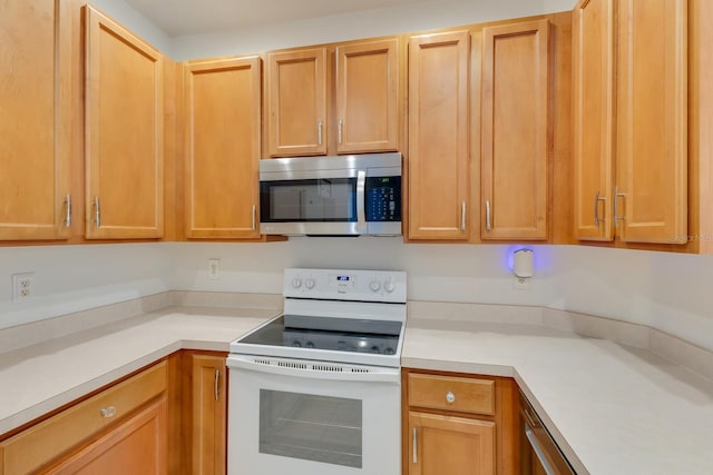 3402 Parkridge Cir, Sarasota, FL 34243 - kitchen featuring stainless steel microwave, white electric stove, and light countertops