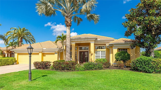 7081 Grassland Ct, Sarasota, FL 34241 - mediterranean / spanish-style house with a tile roof, an attached garage, stucco siding, a front lawn, and driveway