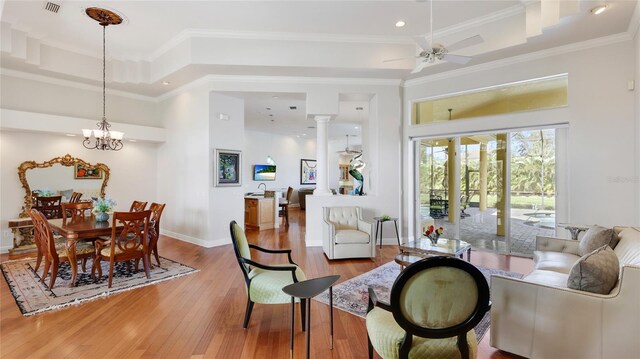 7081 Grassland Ct, Sarasota, FL 34241 - living area with a towering ceiling, light wood finished floors, a ceiling fan, crown molding, and a tray ceiling