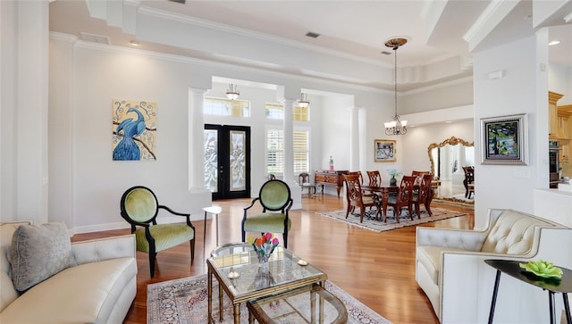 7081 Grassland Ct, Sarasota, FL 34241 - living area with light wood finished floors, ornamental molding, a chandelier, and a tray ceiling