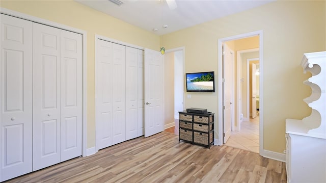 7081 Grassland Ct, Sarasota, FL 34241 - bedroom with two closets, light wood-type flooring, and a ceiling fan