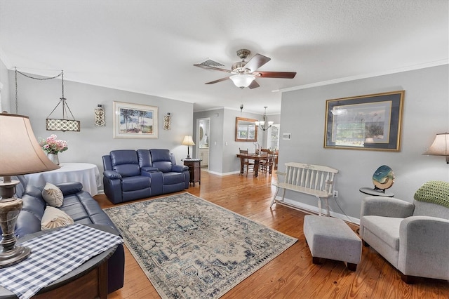 304 34th St W, Bradenton, FL 34205 - living room with ceiling fan, a chandelier, crown molding, wood finished floors, and baseboards