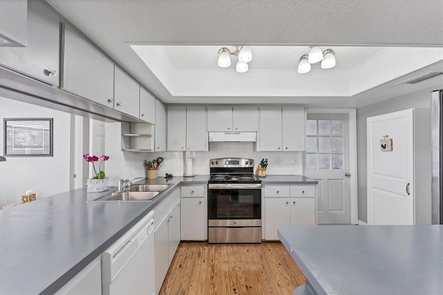 304 34th St W, Bradenton, FL 34205 - kitchen featuring stainless steel range with electric stovetop, dishwasher, a sink, under cabinet range hood, and light wood-type flooring