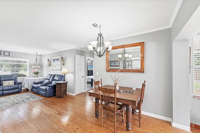 304 34th St W, Bradenton, FL 34205 - dining room featuring a chandelier, light wood-style flooring, ornamental molding, healthy amount of natural light, and baseboards