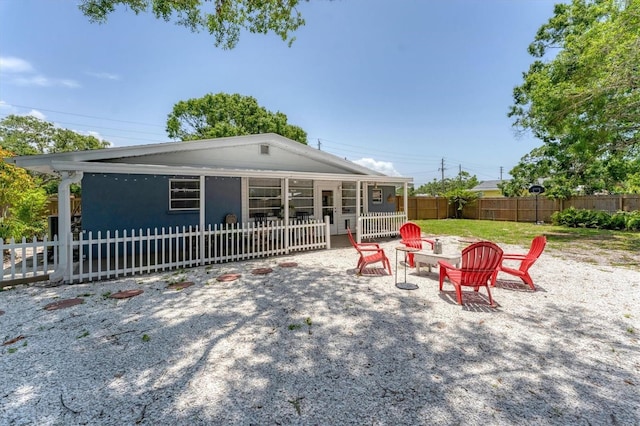 304 34th St W, Bradenton, FL 34205 - rear view of property with a fenced backyard and an outdoor fire pit