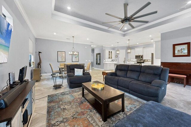 6636 35th Ct E, Sarasota, FL 34243 - living room with a raised ceiling, ceiling fan, recessed lighting, a chandelier, and crown molding