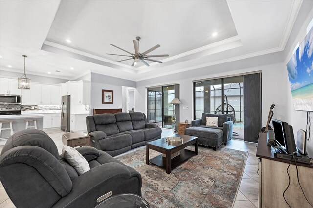 6636 35th Ct E, Sarasota, FL 34243 - living area featuring a raised ceiling, healthy amount of natural light, a ceiling fan, light tile patterned floors, and ornamental molding