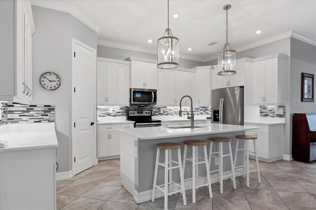6636 35th Ct E, Sarasota, FL 34243 - kitchen with stainless steel appliances, decorative backsplash, a sink, an island with sink, and ornamental molding