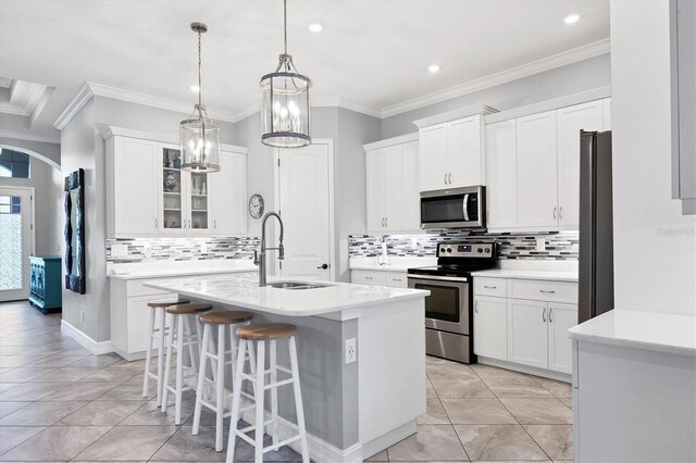 6636 35th Ct E, Sarasota, FL 34243 - kitchen with appliances with stainless steel finishes, a sink, a center island with sink, tasteful backsplash, and light countertops