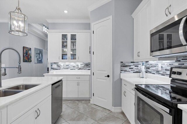 6636 35th Ct E, Sarasota, FL 34243 - kitchen featuring stainless steel appliances, a sink, crown molding, light countertops, and white cabinets