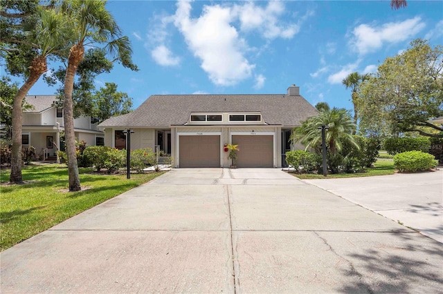 7926 Woodpointe Ct Unit 29, Sarasota, FL 34238 - mid-century inspired home featuring a front lawn, concrete driveway, a chimney, and roof with shingles