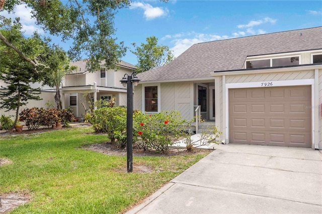 7926 Woodpointe Ct Unit 29, Sarasota, FL 34238 - view of front of property with concrete driveway, a front yard, roof with shingles, and a garage