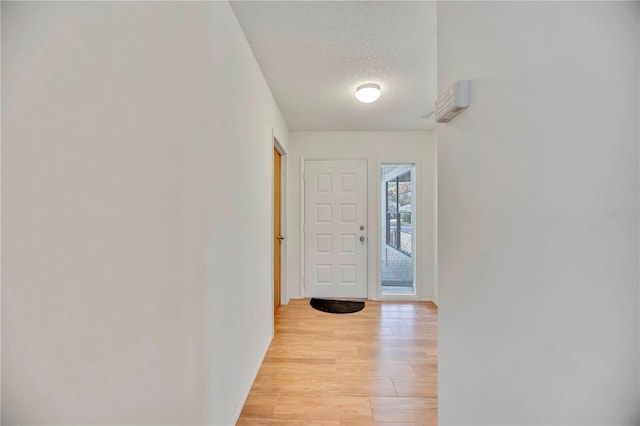 7926 Woodpointe Ct Unit 29, Sarasota, FL 34238 - hall featuring a textured ceiling, light wood-style floors, and baseboards