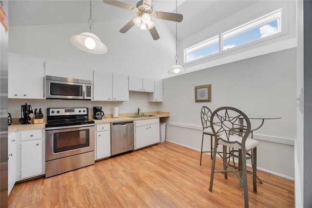 7926 Woodpointe Ct Unit 29, Sarasota, FL 34238 - kitchen with appliances with stainless steel finishes, a sink, light countertops, white cabinets, and high vaulted ceiling