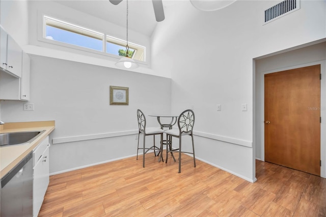 7926 Woodpointe Ct Unit 29, Sarasota, FL 34238 - kitchen featuring stainless steel dishwasher, a sink, white cabinetry, a ceiling fan, and light wood-style floors