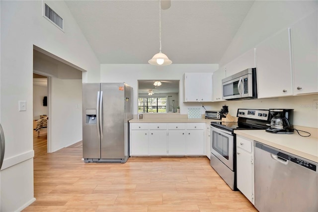 7926 Woodpointe Ct Unit 29, Sarasota, FL 34238 - kitchen featuring appliances with stainless steel finishes, light countertops, white cabinetry, light wood-type flooring, and lofted ceiling