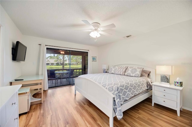 7926 Woodpointe Ct Unit 29, Sarasota, FL 34238 - bedroom featuring access to exterior, light wood-type flooring, a ceiling fan, and a textured ceiling