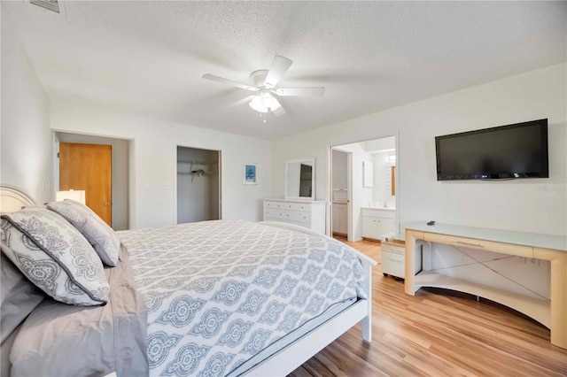 7926 Woodpointe Ct Unit 29, Sarasota, FL 34238 - bedroom featuring light wood finished floors, ensuite bath, a ceiling fan, a textured ceiling, and a closet