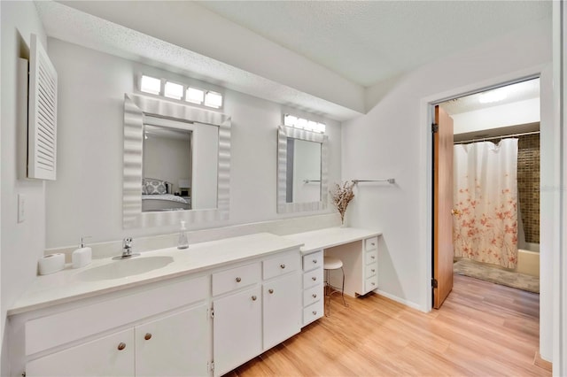 7926 Woodpointe Ct Unit 29, Sarasota, FL 34238 - full bathroom featuring wood finished floors, vanity, ensuite bath, a textured ceiling, and baseboards