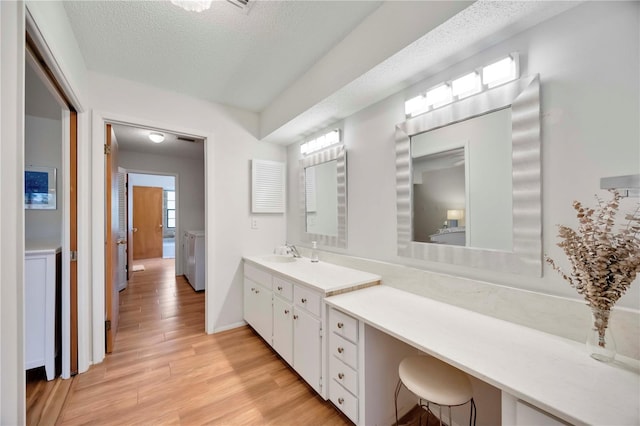 7926 Woodpointe Ct Unit 29, Sarasota, FL 34238 - bathroom featuring a textured ceiling, wood finished floors, vanity, and baseboards