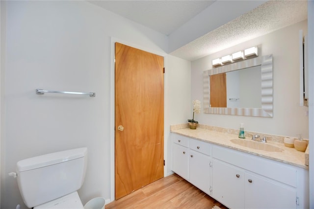 7926 Woodpointe Ct Unit 29, Sarasota, FL 34238 - bathroom featuring vanity, toilet, wood finished floors, and a textured ceiling