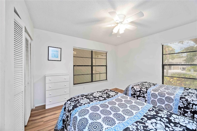 7926 Woodpointe Ct Unit 29, Sarasota, FL 34238 - bedroom with wood finished floors, a closet, a textured ceiling, and ceiling fan