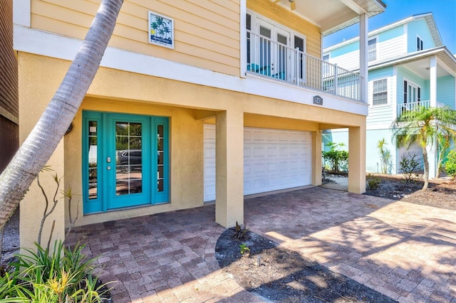 145 50th St, Holmes Beach, FL 34217 - entrance to property featuring an attached garage, decorative driveway, and stucco siding