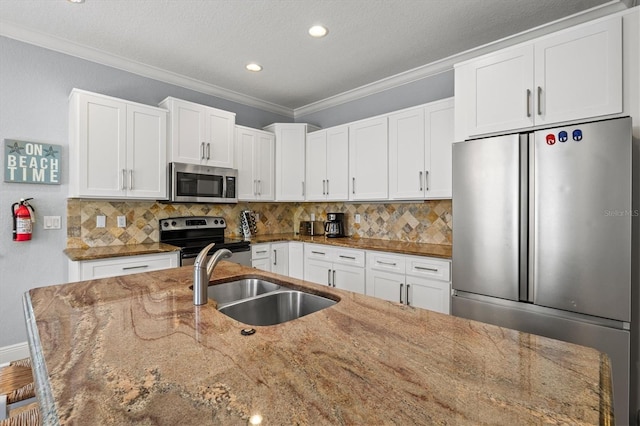 145 50th St, Holmes Beach, FL 34217 - kitchen with stainless steel appliances, ornamental molding, white cabinets, backsplash, and light stone counters