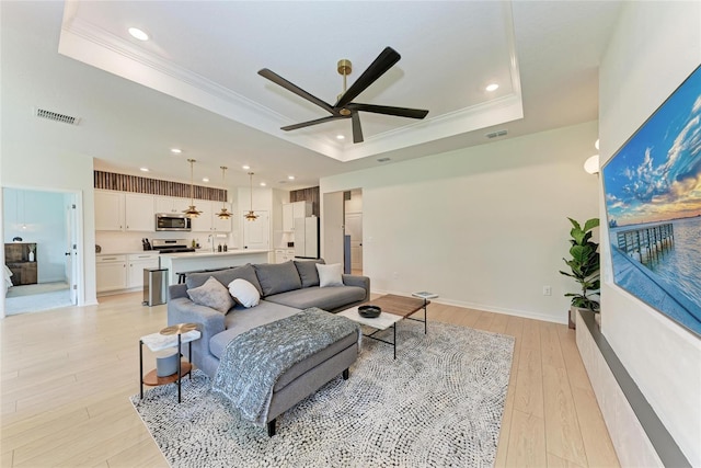 3129 61st Ter E, Ellenton, FL 34222 - living area featuring a raised ceiling, ornamental molding, ceiling fan, recessed lighting, and light wood-style floors