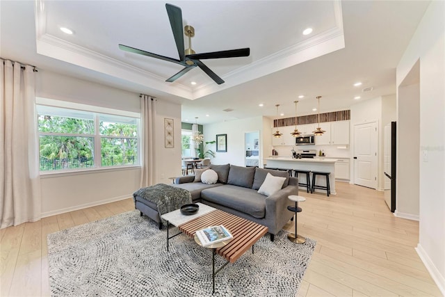3129 61st Ter E, Ellenton, FL 34222 - living area with a tray ceiling, ornamental molding, light wood-type flooring, a ceiling fan, and baseboards
