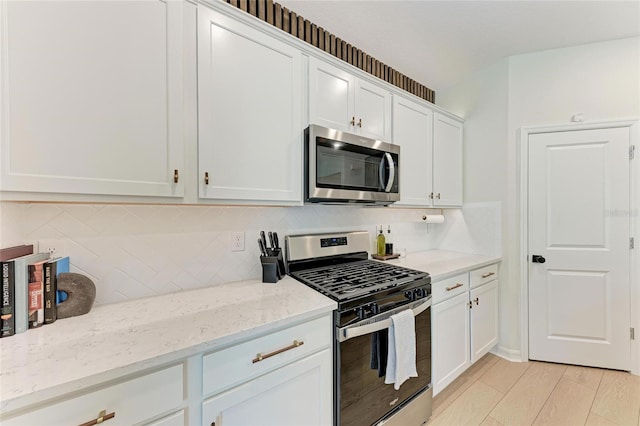 3129 61st Ter E, Ellenton, FL 34222 - kitchen featuring stainless steel appliances, white cabinetry, light stone countertops, and decorative backsplash
