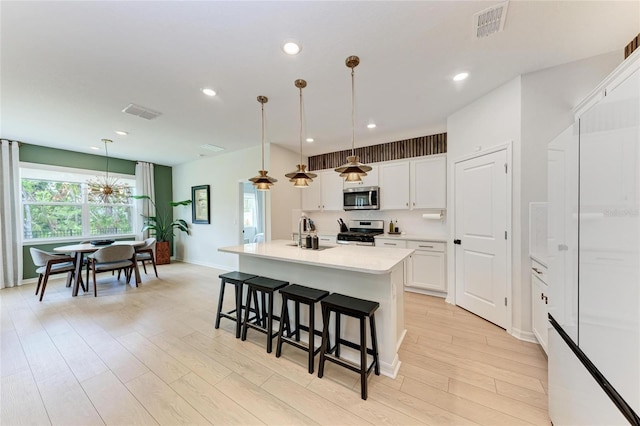 3129 61st Ter E, Ellenton, FL 34222 - kitchen featuring appliances with stainless steel finishes, a sink, a breakfast bar, white cabinets, and baseboards