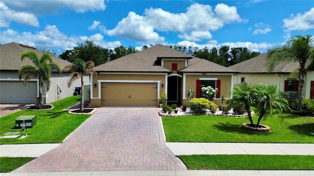 3712 76th St E, Palmetto, FL 34221 - view of front of property with stucco siding, an attached garage, and a front lawn
