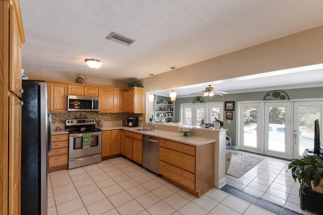 715 Fontana Ln, Bradenton, FL 34209 - kitchen featuring stainless steel appliances, a peninsula, light countertops, light tile patterned flooring, and a sink
