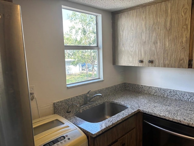10800 N US Highway 19 Unit 237, Pinellas Park, FL 33782 - kitchen with dishwasher, a sink, light stone counters, a textured ceiling, and washer / dryer