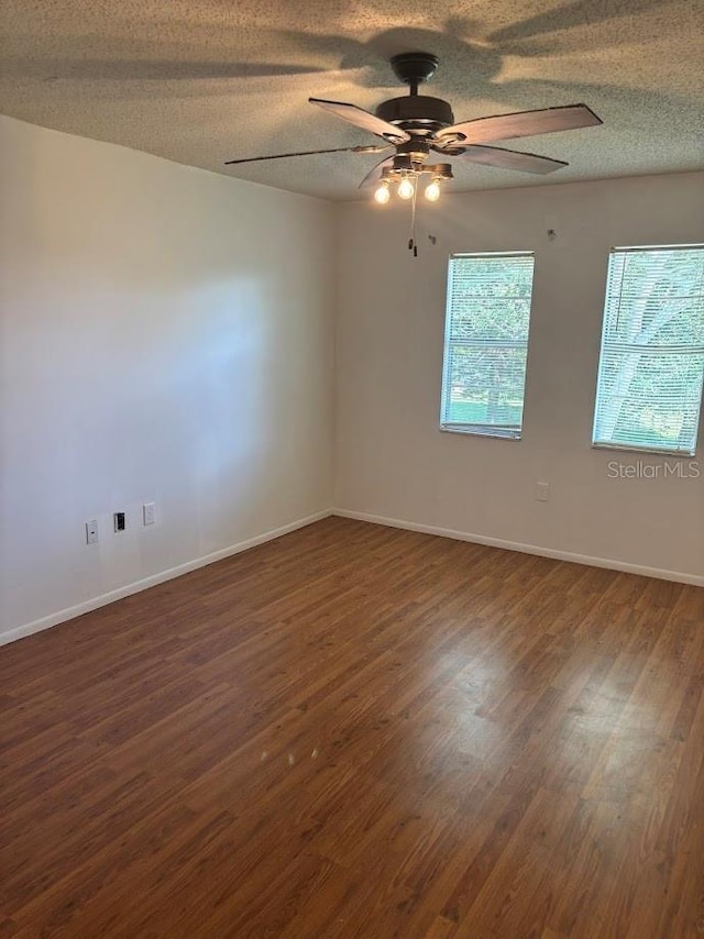 10800 N US Highway 19 Unit 237, Pinellas Park, FL 33782 - spare room featuring a ceiling fan, dark wood-style flooring, a textured ceiling, and baseboards