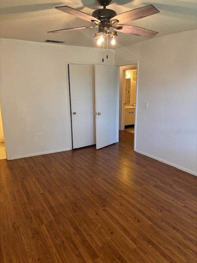10800 N US Highway 19 Unit 237, Pinellas Park, FL 33782 - unfurnished bedroom featuring dark wood finished floors, baseboards, a closet, a ceiling fan, and a textured ceiling