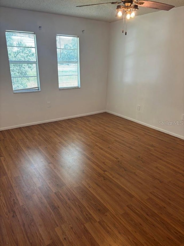 10800 N US Highway 19 Unit 237, Pinellas Park, FL 33782 - empty room with ceiling fan, wood finished floors, a textured ceiling, and baseboards