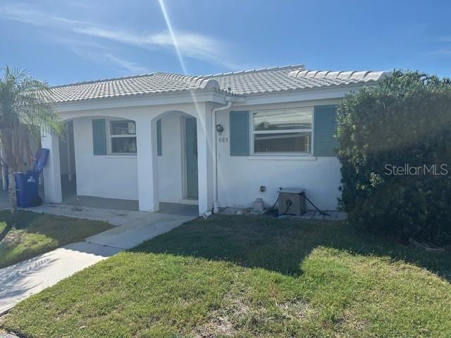 683 Spanish Dr S, Longboat Key, FL 34228 - view of front of property featuring a front yard, stucco siding, and a tiled roof