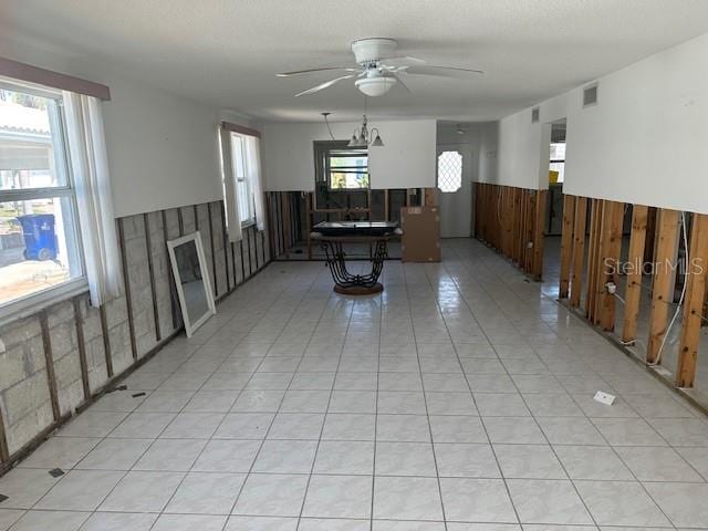 683 Spanish Dr S, Longboat Key, FL 34228 - living room featuring a wainscoted wall, ceiling fan, and light tile patterned floors