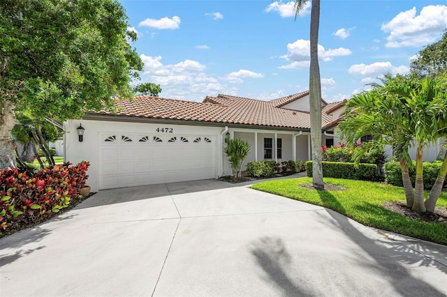 4472 Calle Serena, Sarasota, FL 34238 - mediterranean / spanish-style house with stucco siding, a garage, concrete driveway, a tile roof, and a front yard