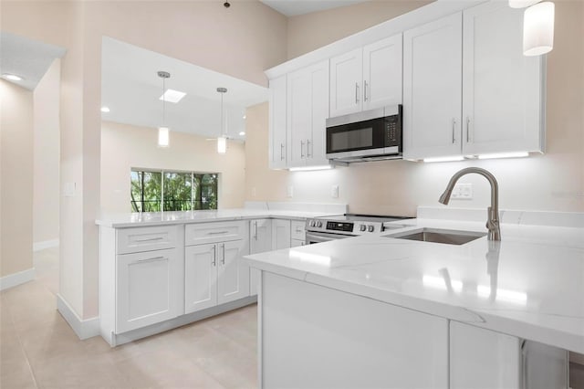 4472 Calle Serena, Sarasota, FL 34238 - kitchen with stainless steel appliances, a sink, a peninsula, white cabinetry, and light stone counters