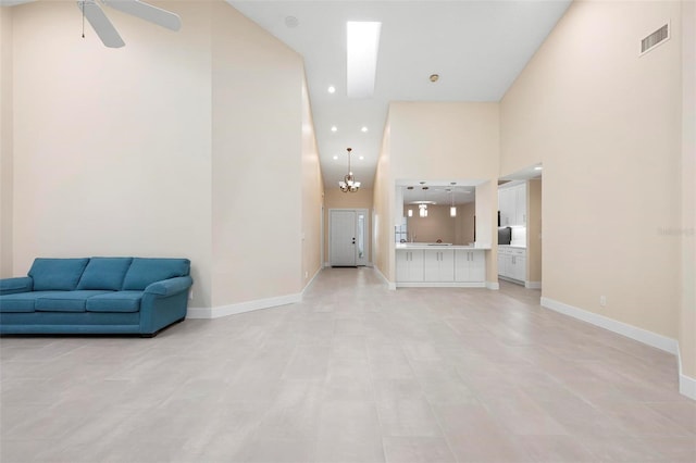 4472 Calle Serena, Sarasota, FL 34238 - unfurnished living room featuring a towering ceiling, a ceiling fan, baseboards, recessed lighting, and a chandelier